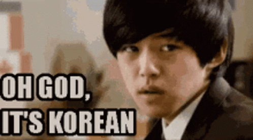 A Young Man In A Suit And Tie Is Looking At The Camera With The Words Oh God It 'S Korean Above Him . GIF