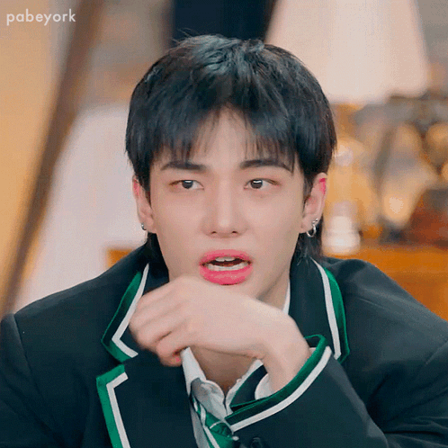 A Young Man In A Suit And Tie Is Making A Funny Face GIF