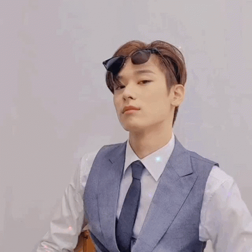 A Young Man In A Suit And Tie Is Wearing Sunglasses And Giving A Thumbs Up . GIF