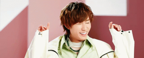 a young man in a white jacket is making a funny face with his hands in the air