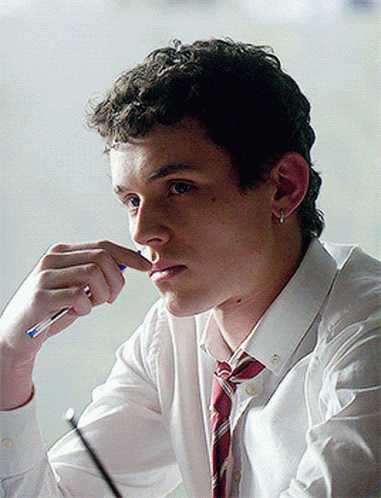 A Young Man In A White Shirt And Red Tie Is Holding A Pen To His Nose GIF