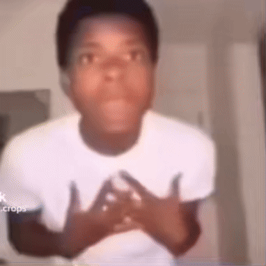 A Young Man In A White Shirt Is Making A Funny Face With His Hands On His Chest . GIF