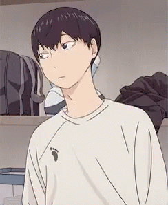 A Young Man In A White Shirt Is Standing In A Room . GIF