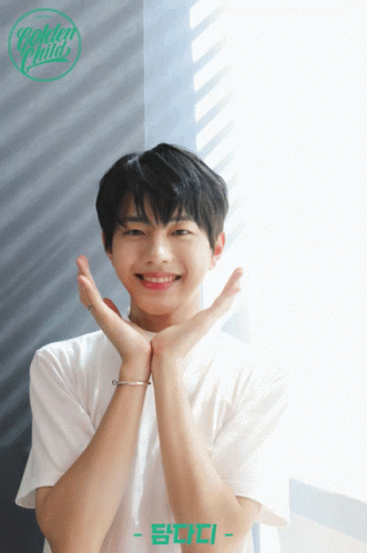 A Young Man In A White Shirt With The Name Golden Child On The Bottom Right GIF