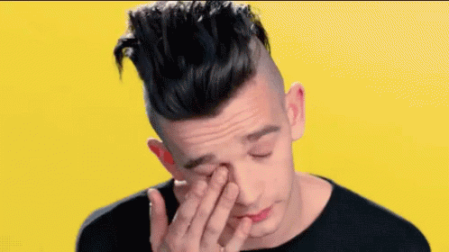 A Young Man Is Covering His Face With His Hand . GIF