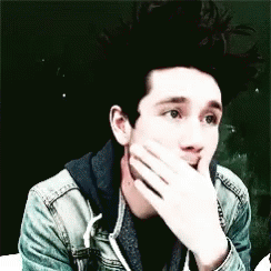 A Young Man Is Covering His Mouth With His Hand . GIF