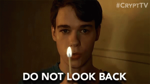 A Young Man Is Holding A Lit Match In Front Of His Face And Says `` Do Not Look Back '' . GIF