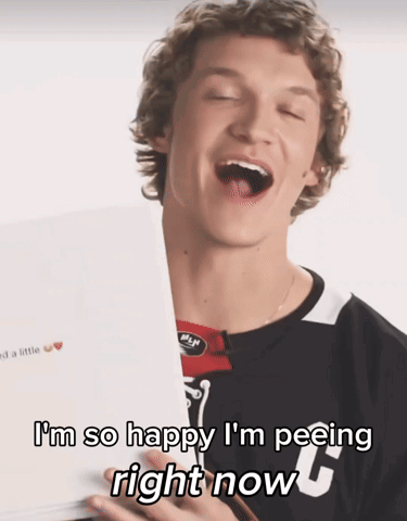 A Young Man Is Holding A Piece Of Paper With The Words I 'M So Happy I 'M Peeing Right Now On It GIF