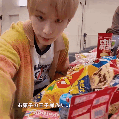 a young man is looking at a bag of chips that says chi star on it