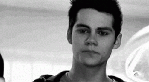 A Young Man Is Looking At The Camera In A Black And White Photo . GIF