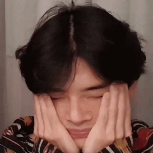 A Young Man Is Making A Face With His Hands . GIF