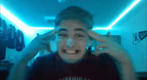 A Young Man Is Making A Funny Face In Front Of A Blue Light GIF