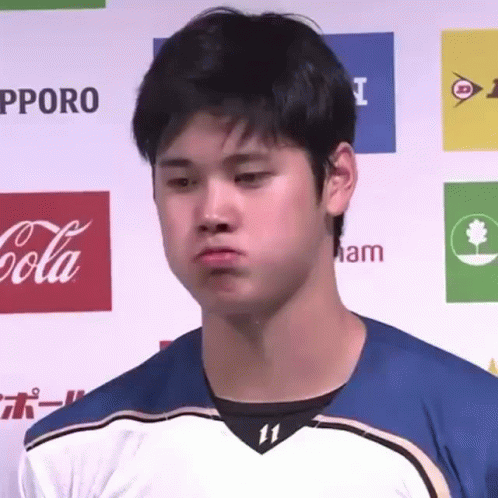 A Young Man Is Making A Funny Face In Front Of A Coca Cola Banner . GIF
