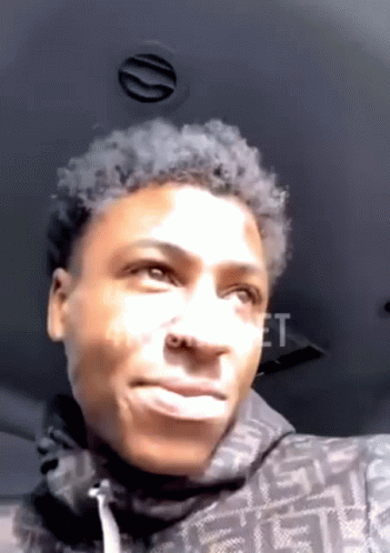 A Young Man Is Making A Funny Face While Sitting In The Back Of A Car . GIF