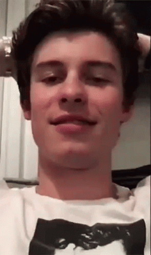 A Young Man Is Making A Funny Face While Wearing A White T-Shirt With A Picture On It . GIF
