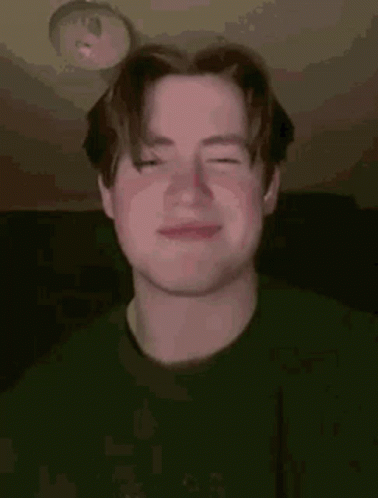 A Young Man Is Making A Funny Face With His Eyes Closed . GIF