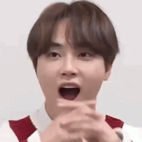 A Young Man Is Making A Funny Face With His Mouth Open And His Hands Folded . GIF
