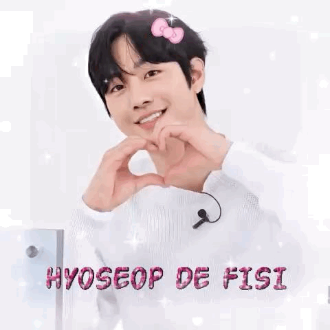 A Young Man Is Making A Heart Shape With His Hands While Wearing A Hello Kitty Headband . GIF