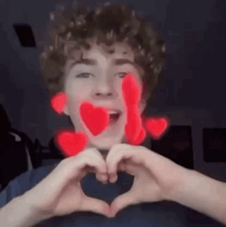 A Young Man Is Making A Heart With His Hands . GIF