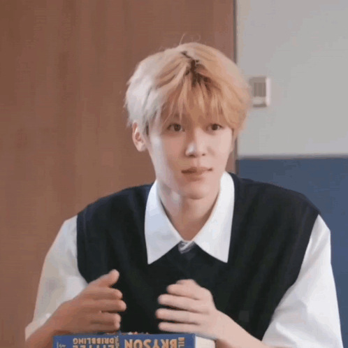 A Young Man Is Sitting At A Table With A Box Of Skyson GIF
