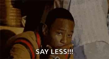 A Young Man Is Sitting Down With His Hand On His Chin And Saying `` Say Less !! '' . GIF