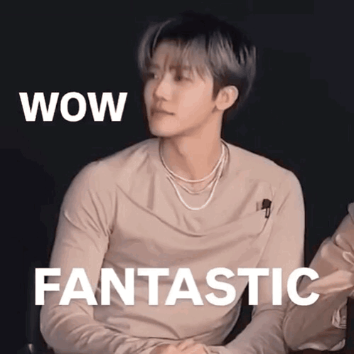 A Young Man Is Sitting In Front Of A Sign That Says Wow Fantastic . GIF