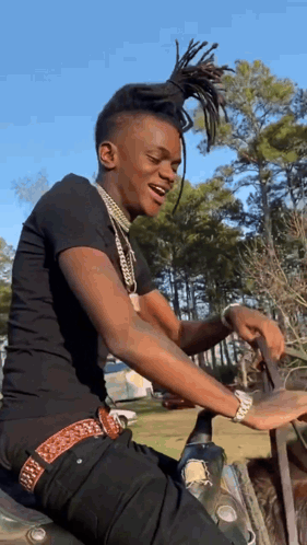 A Young Man Is Sitting On A Motorcycle In The Woods . GIF