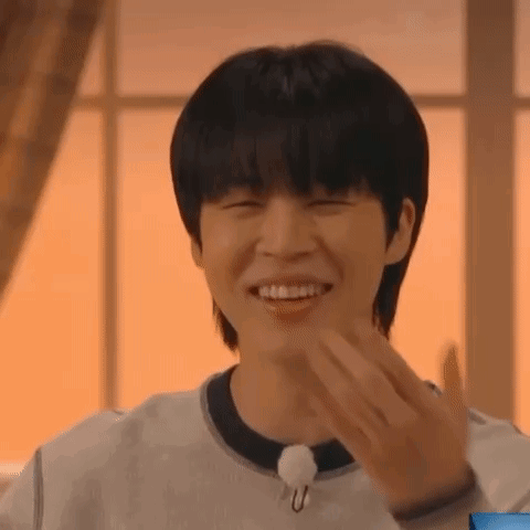 A Young Man Is Smiling And Making A Funny Face While Wearing A White Shirt . GIF