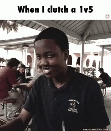 A Young Man Is Smiling While Sitting At A Picnic Table In Front Of A Group Of People . GIF