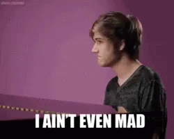 A Young Man Is Standing In Front Of A Purple Wall And Says `` I Ain 'T Even Mad '' . GIF