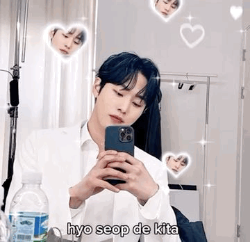 A Young Man Is Taking A Selfie In Front Of A Mirror With His Phone . GIF