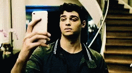 A Young Man Is Taking A Selfie With His Cell Phone In Front Of Stairs . GIF