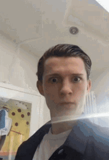 A Young Man Is Taking A Selfie With His Face Reflected In A Mirror . GIF