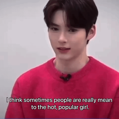A Young Man Is Wearing A Red Sweater And Talking To A Camera . GIF