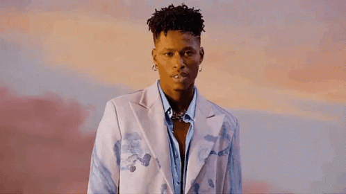 A Young Man Is Wearing A White Jacket And A Blue Shirt . GIF