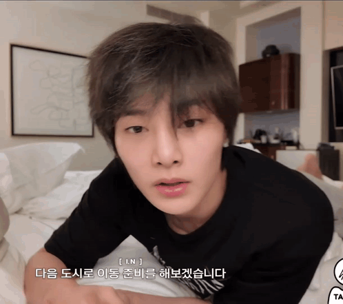 A Young Man Laying On A Bed With Korean Writing On The Bottom Of His Face GIF
