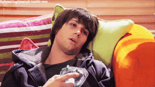 A Young Man Laying On A Couch With A Bottle Of Water In His Hand GIF