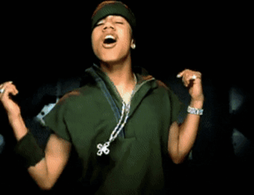 A Young Man Singing Into A Microphone Wearing A Green Jacket And A Beanie GIF