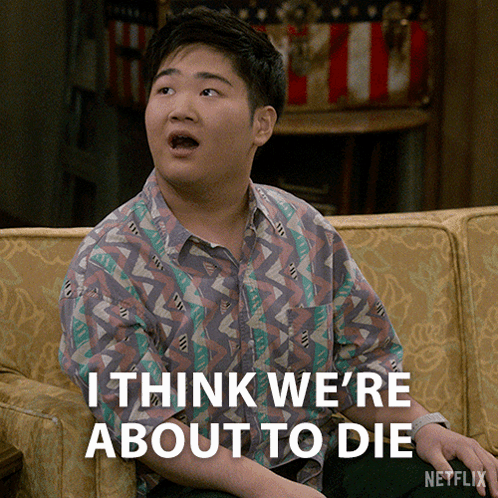 A Young Man Sitting On A Couch With The Words " I Think We 'Re About To Die " Below Him GIF