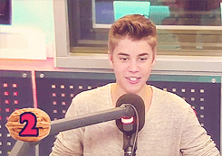 A Young Man Stands In Front Of A Microphone With The Number 2 On A Nut GIF