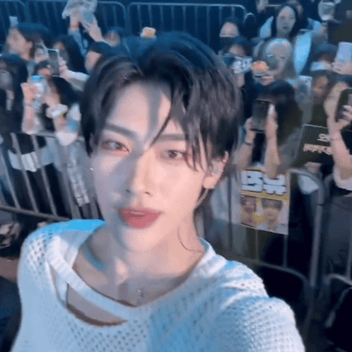 A Young Man Taking A Selfie In Front Of A Crowd Of People GIF