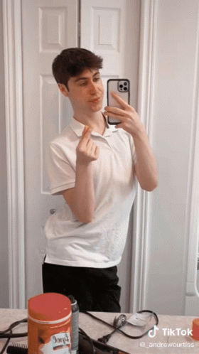 A Young Man Taking A Selfie In Front Of A Mirror With A Tiktok Watermark On The Bottom GIF