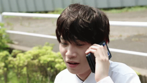 A Young Man Talking On A Cell Phone With A Surprised Look On His Face GIF
