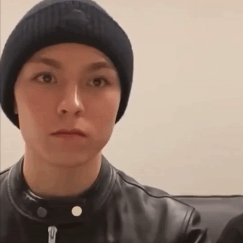 A Young Man Wearing A Beanie And A Leather Jacket Is Making A Funny Face . GIF