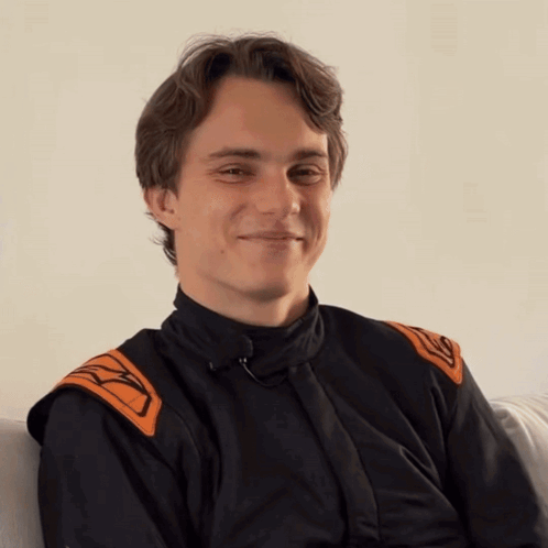 A Young Man Wearing A Black And Orange Jacket With The Letter K On The Sleeves GIF