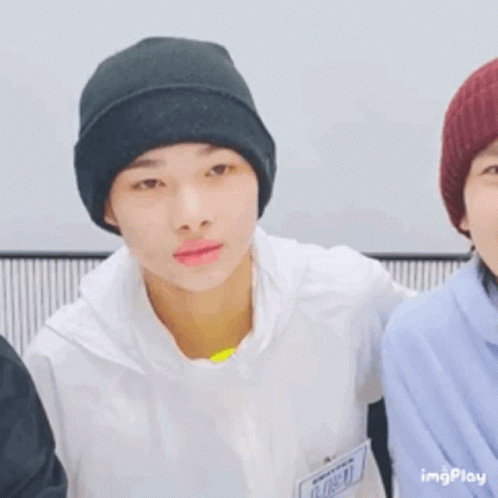 A Young Man Wearing A Black Beanie Is Smiling While Standing Next To Another Young Man . GIF