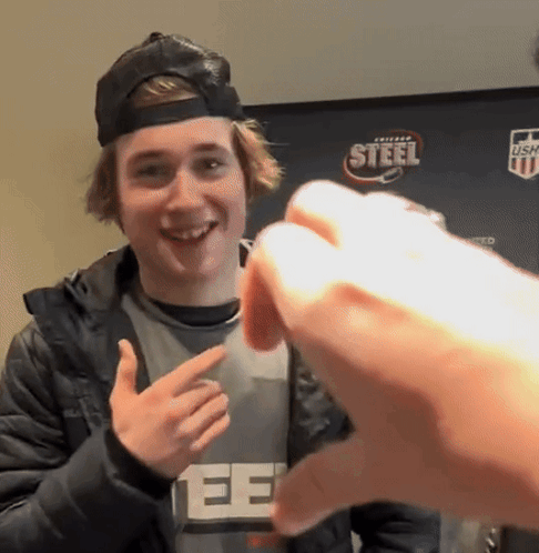 A Young Man Wearing A Black Hat And A Gray Shirt With The Word Steel On It GIF