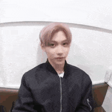 Young Man In Black Jacket Sitting On Couch GIF