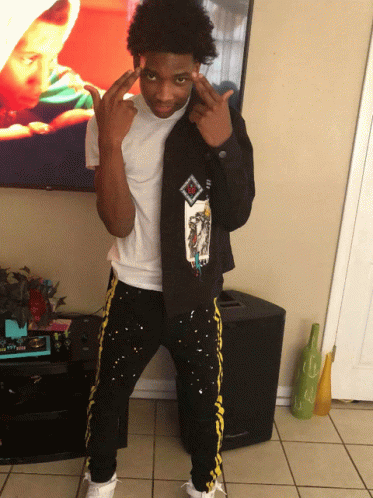 A Young Man Wearing A Black Jacket With A Picture Of A Baby On It GIF