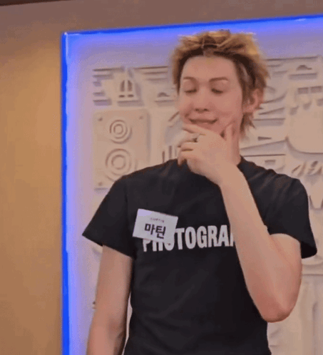 A Young Man Wearing A Black Photographer T-Shirt GIF